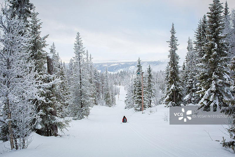 冬日午后坐在挪威海姆斯达尔雪地里的女人图片素材