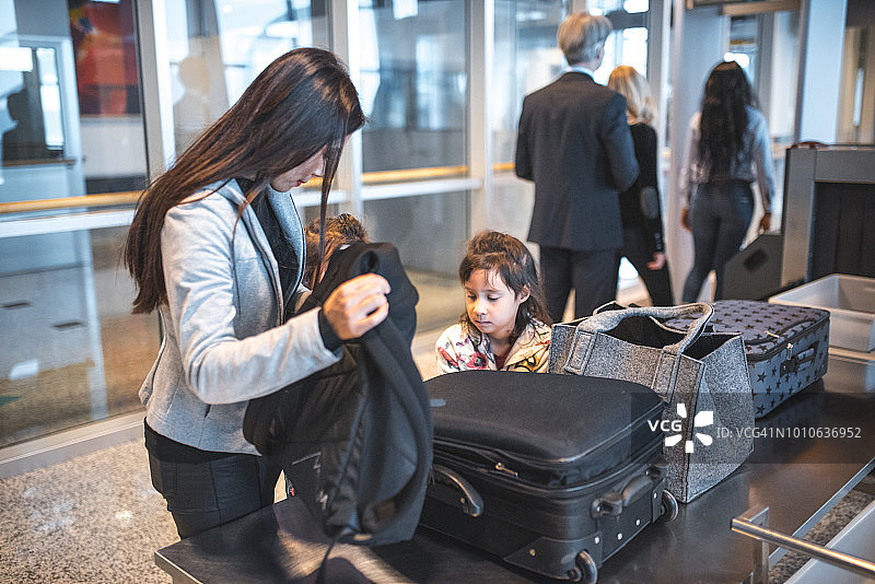 一家人在机场安检处，带着行李图片素材