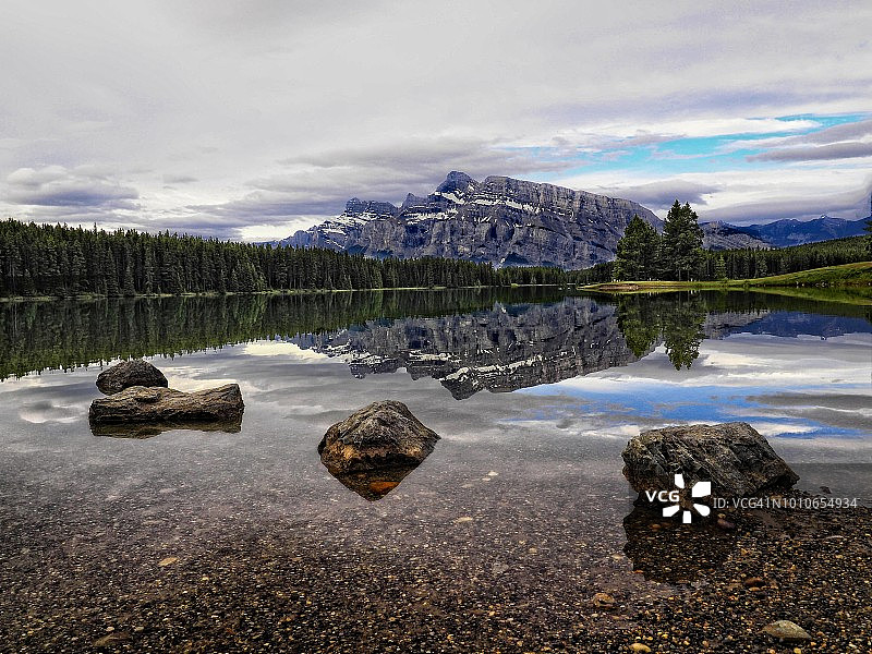 伦德尔山在双杰克湖的倒影，前景是岩石海岸线图片素材