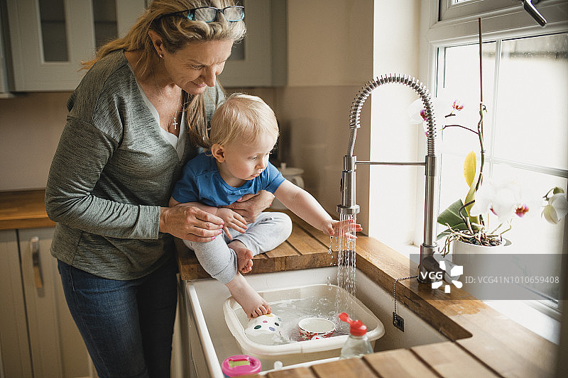 祖母帮助孙子洗手图片素材