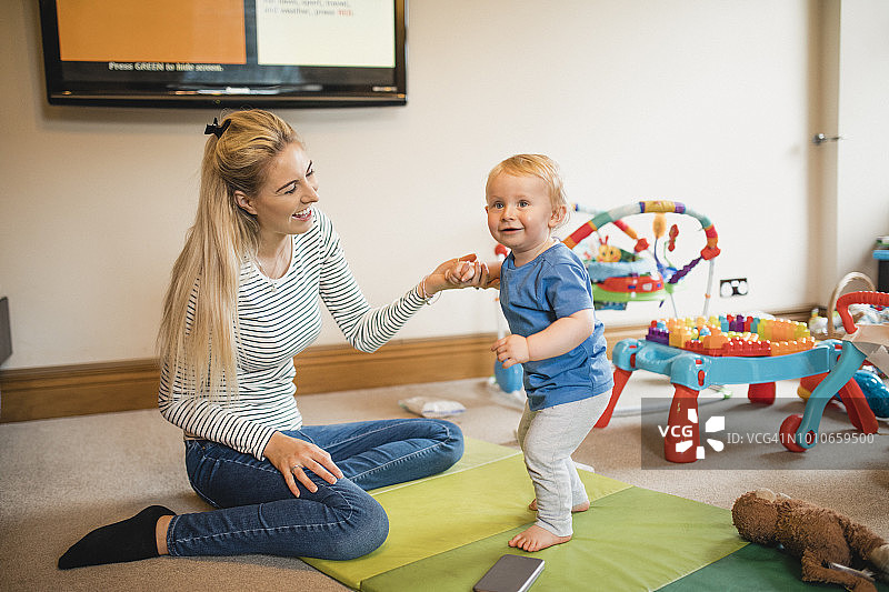母亲帮助她的儿子走路图片素材