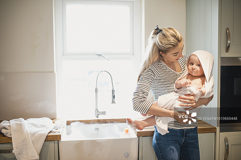 母亲用毛巾抱着男婴图片素材