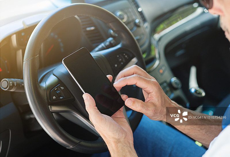 男人在车内使用智能手机图片素材
