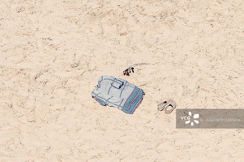 地中海沙滩上的毛巾、太阳镜和帆布鞋图片素材