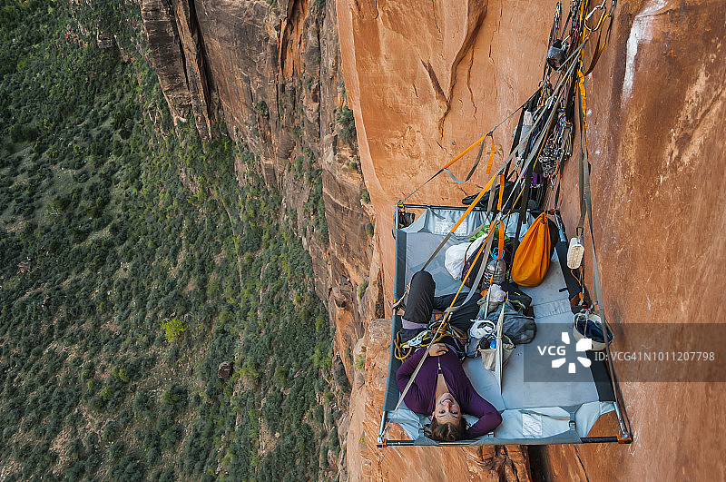 在美国犹他州锡安国家公园，女子躺在悬崖营地上图片素材