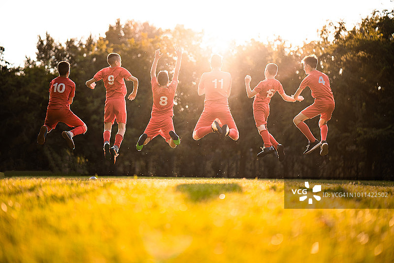 公园里踢足球的球员的背影图片素材