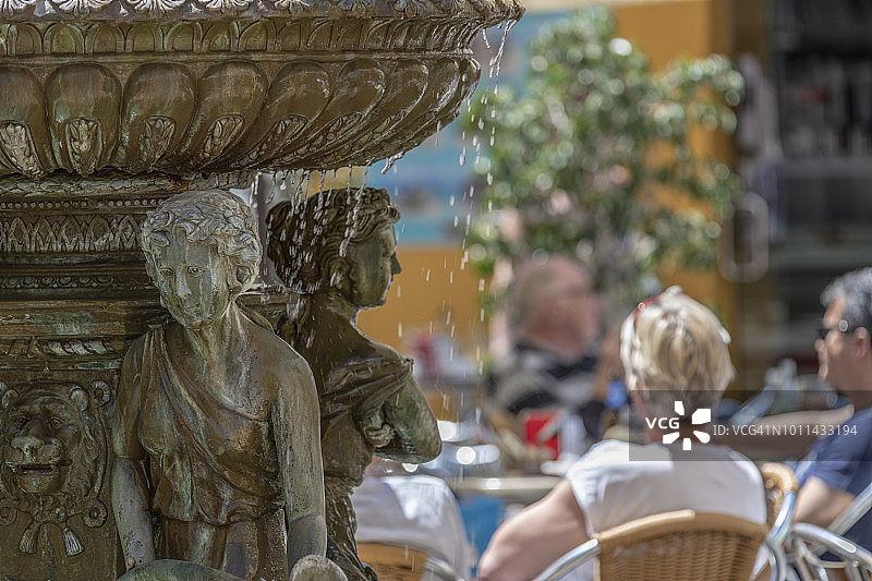 阿尔塞博士广场的喷泉，人们在吃喝和听音乐图片素材