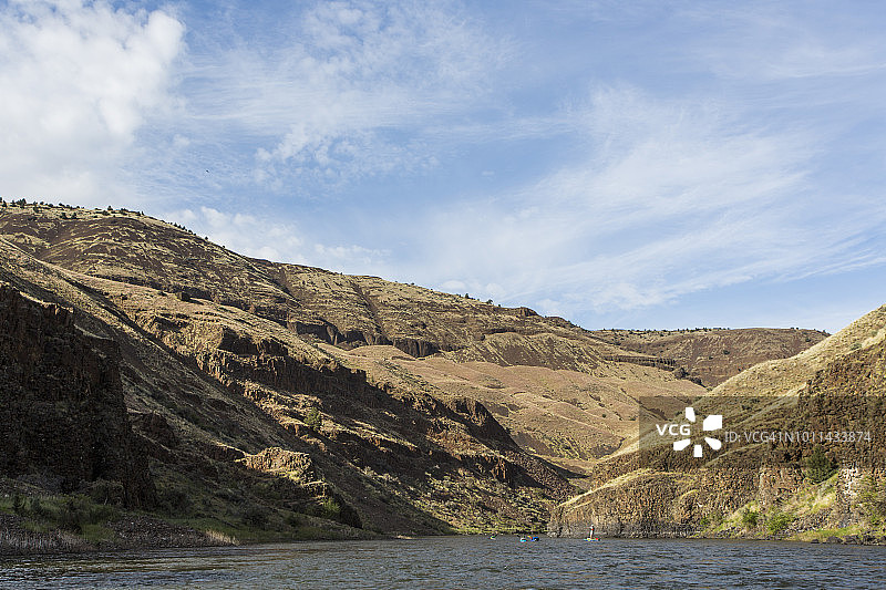 一群桨手在立式桨板和皮划艇上漂浮在俄勒冈州东部的约翰·戴河上图片素材