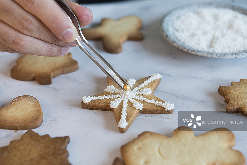 男人装饰圣诞饼干，特写图片素材