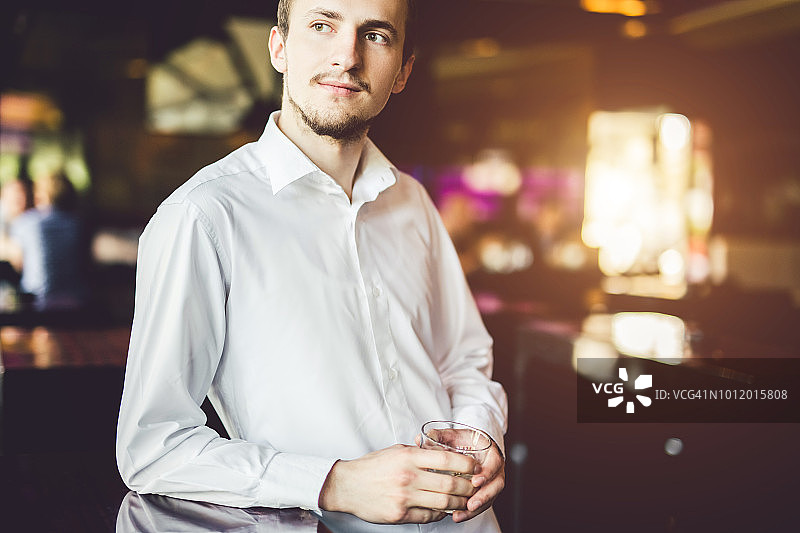 在咖啡馆里喝着他最喜欢的酒精饮料的男人图片素材