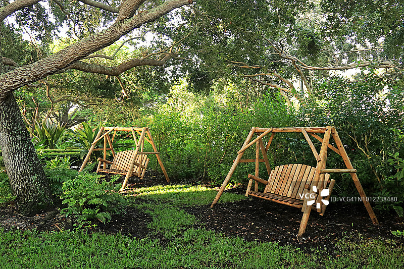 佛罗里达橡树下的独立式木制长椅图片素材