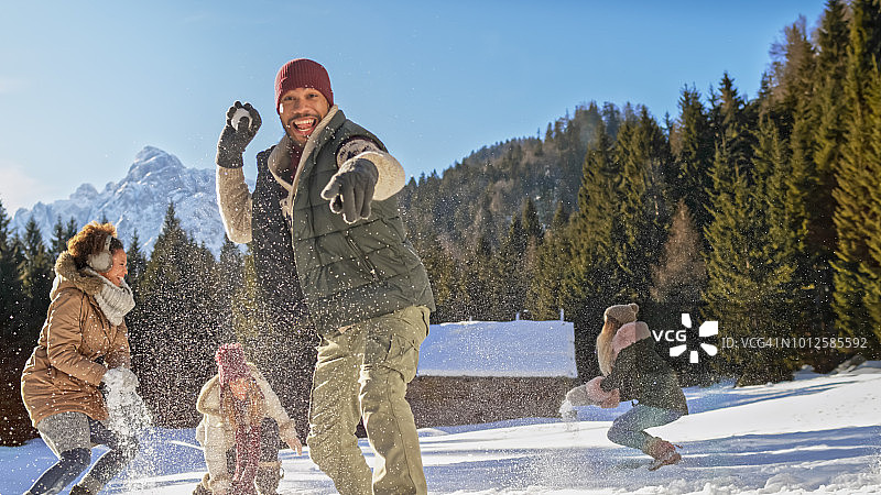 朋友们在阳光明媚的雪地里打雪仗图片素材