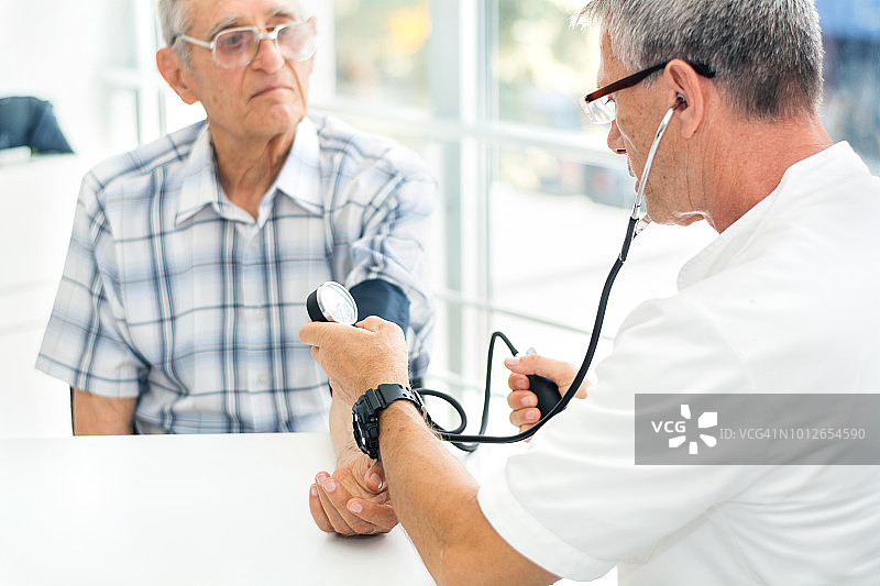 医生为老年男性测量血压图片素材