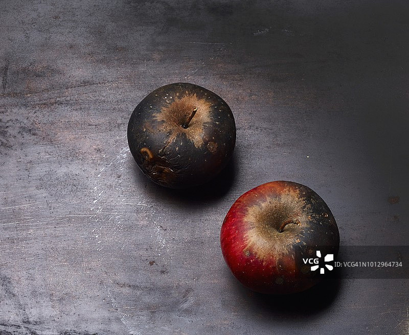黑色烤盘上的两个霉变苹果图片素材