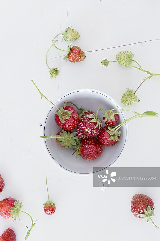 白色木质表面瓷杯中的草莓图片素材