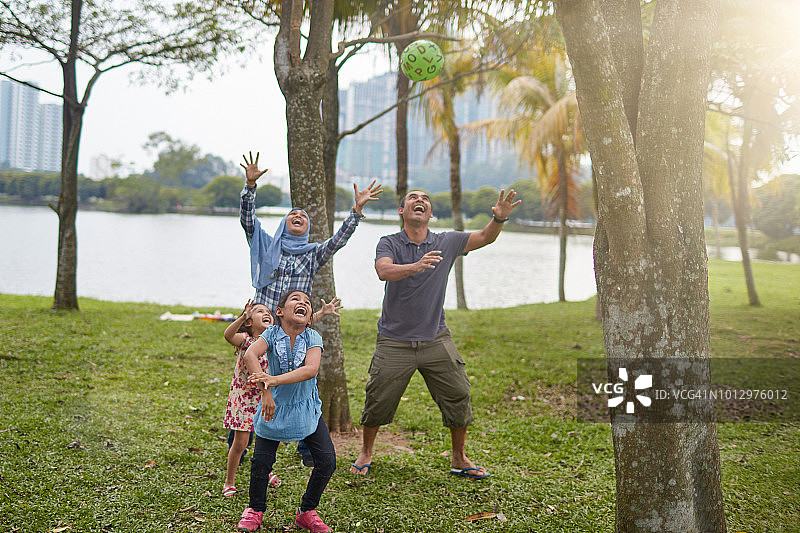 一家人在公园的树林中玩球图片素材