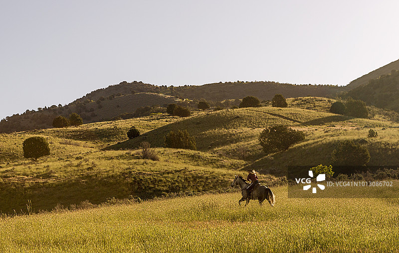 牛仔和女牛仔在盐湖城圣塔金山谷骑马图片素材