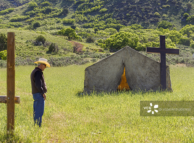 在盐湖城圣奎因山谷乡村帐篷教堂旁的牛仔图片素材