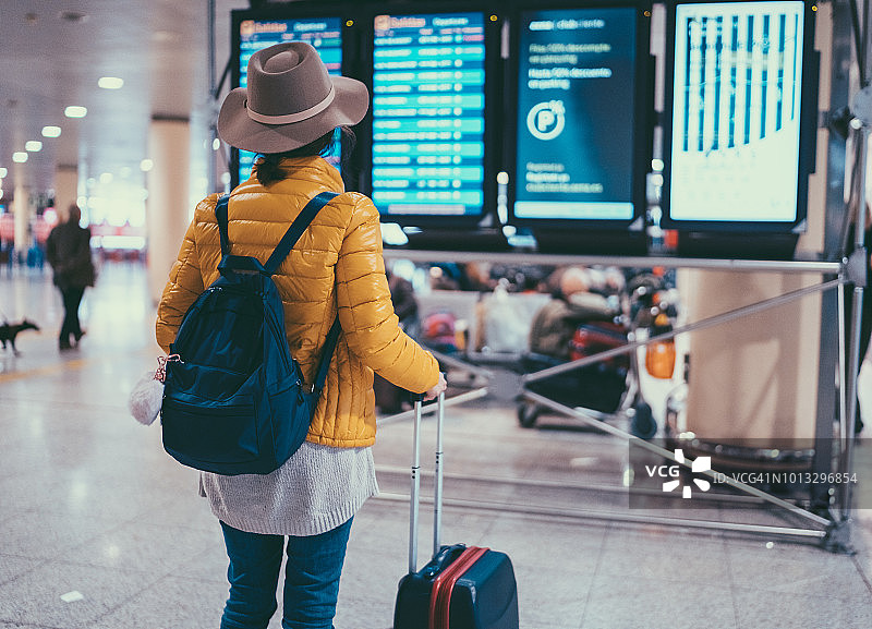 在巴塞罗那机场查看到达出发信息板的游客图片素材