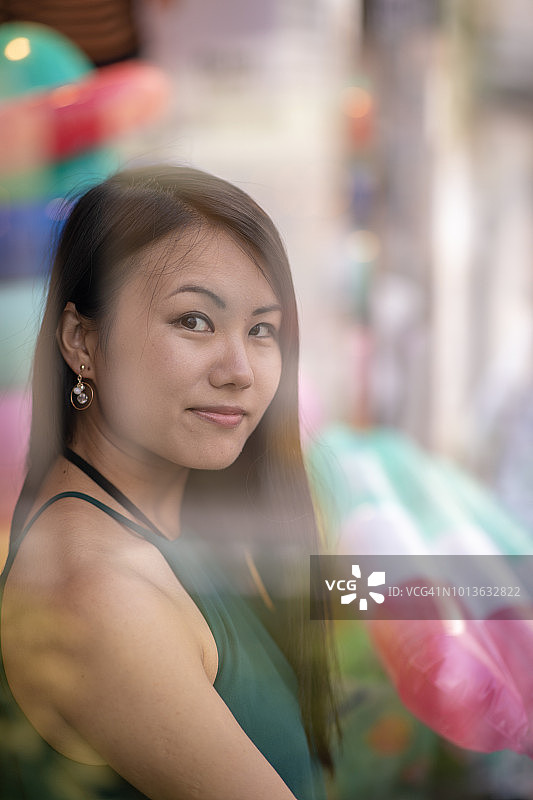 透过商店橱窗观看的年轻女人图片素材