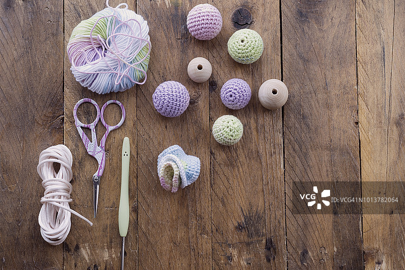学习手工物件：初学者钩针入门，彩色毛线球、钩针、剪刀和针织玩偶球，在乡村木桌上图片素材