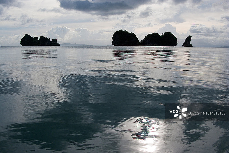 日落时分，菲律宾莱特湾圣佩德罗湾，马拉布特群岛岩石灰岩露头的水面反射图片素材