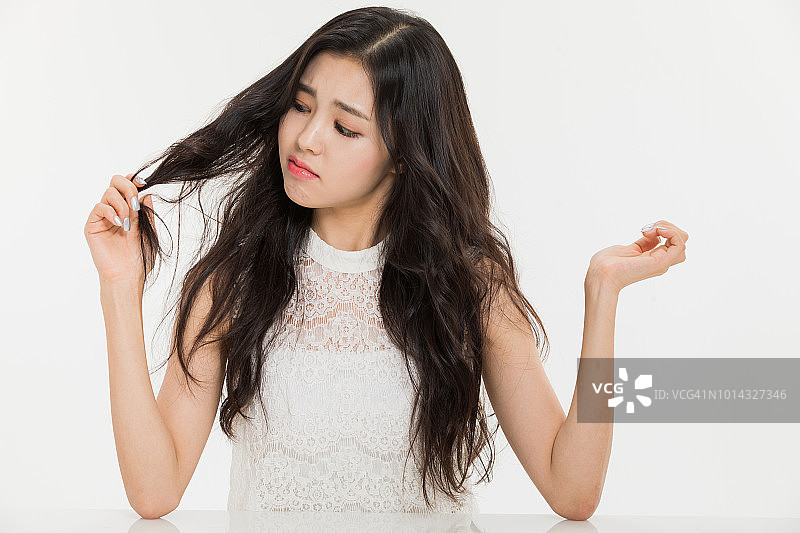 女性正在看她受损的头发图片素材