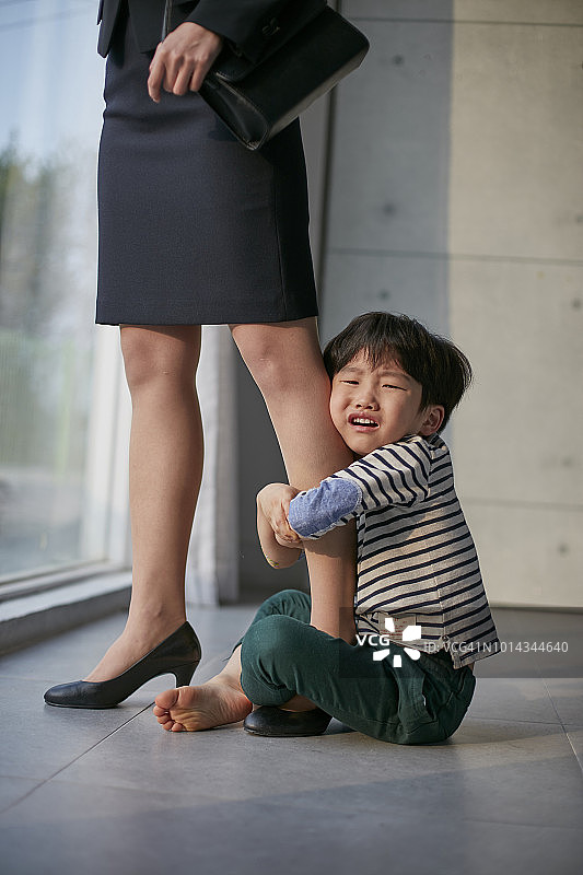 疲惫的工作妈妈和她爱玩耍的儿子图片素材