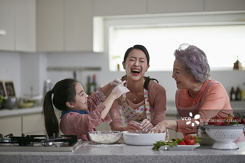 祖母、妈妈和孙女享受烹饪的乐趣图片素材