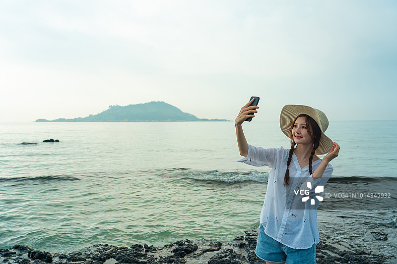 站在海滩上自拍的女人图片素材