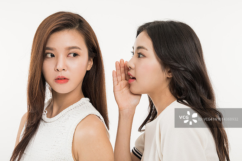 女人在朋友耳边低语图片素材