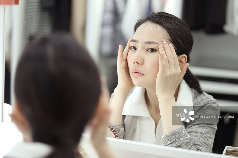 女人在镜子中检查皱纹特写图片素材