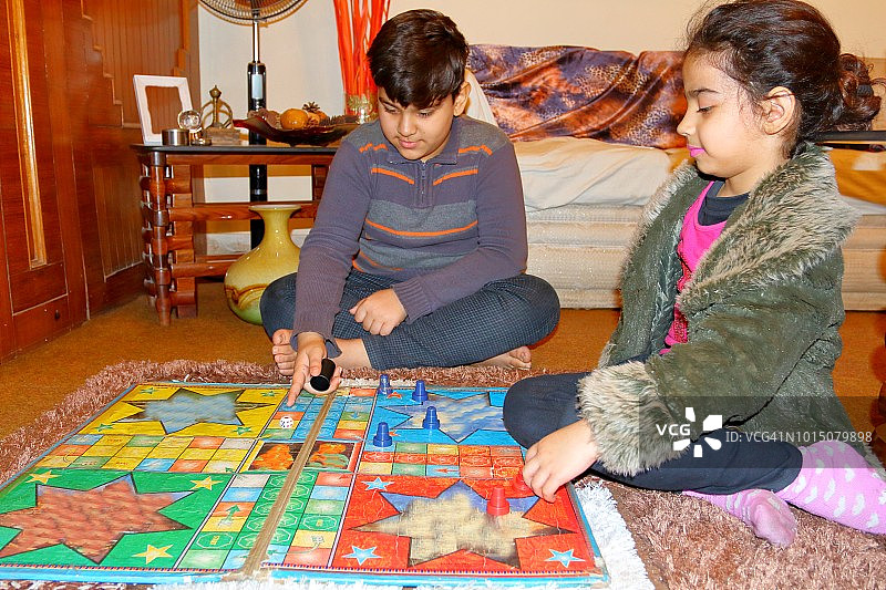 姐弟一起玩飞行棋（棋盘游戏）图片素材