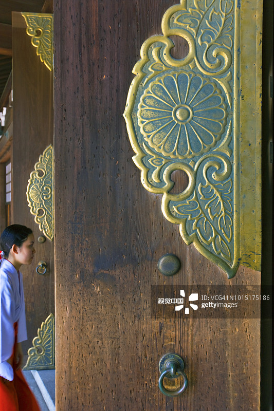 东京明治神宫本殿的巨大木门和巫女图片素材