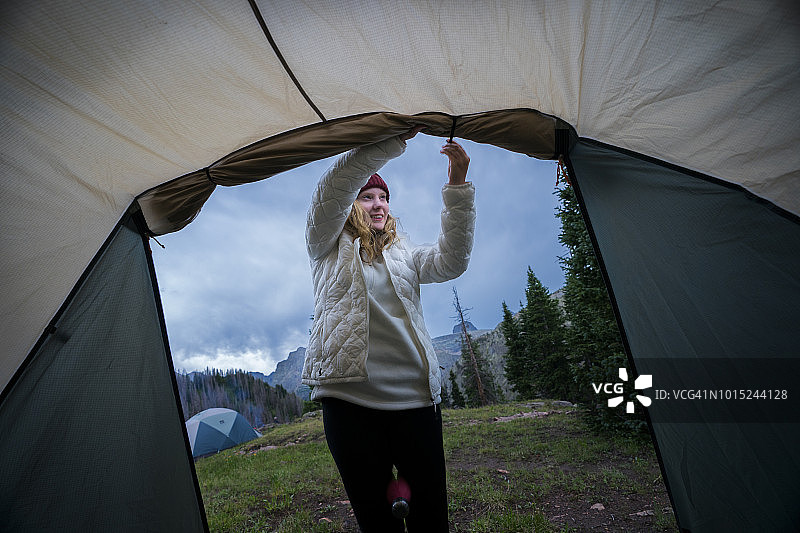 露营时固定帐篷防雨盖的少女图片素材