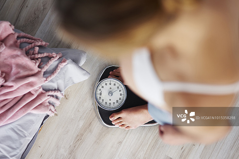 站在体重秤上的孕妇图片素材