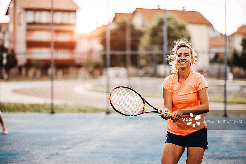 快乐的年轻女孩打网球图片素材