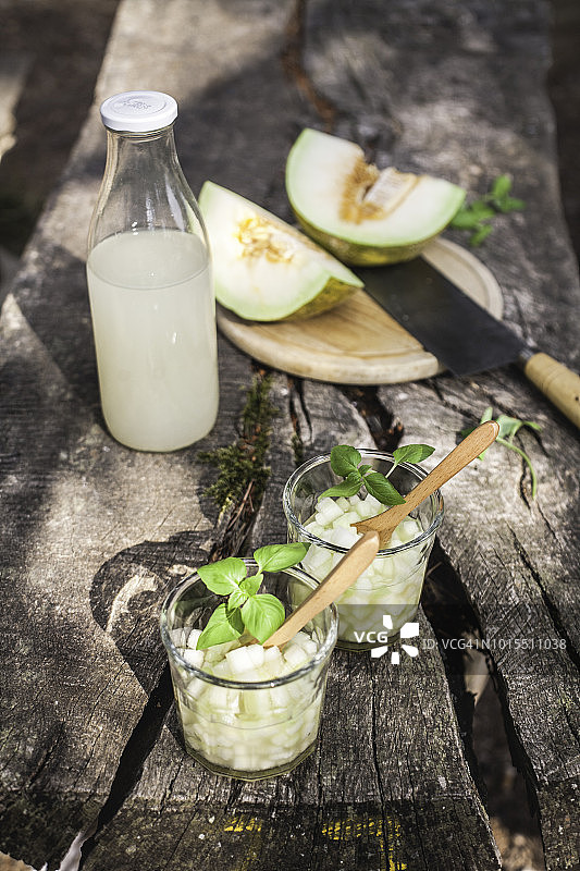 森林中木制野餐桌上的甜瓜汁图片素材