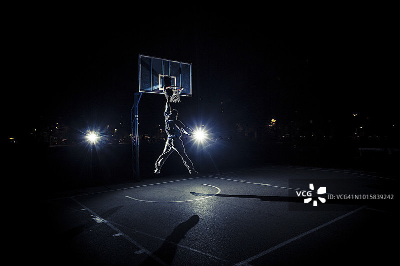 年轻男人夜晚打篮球图片素材