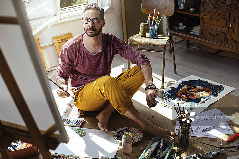 在画布上绘画的男人图片素材