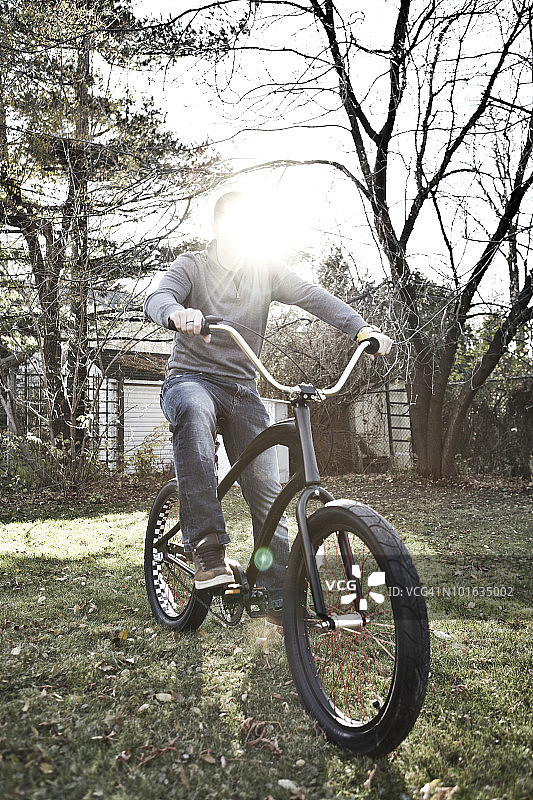 男人在傍晚的阳光下骑着巡洋自行车图片素材