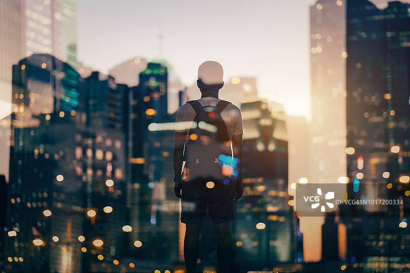 城市夜景与俯瞰城市男人的背影的双重曝光图片素材