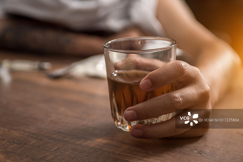 在酒吧里喝白兰地酒的醉酒男人图片素材