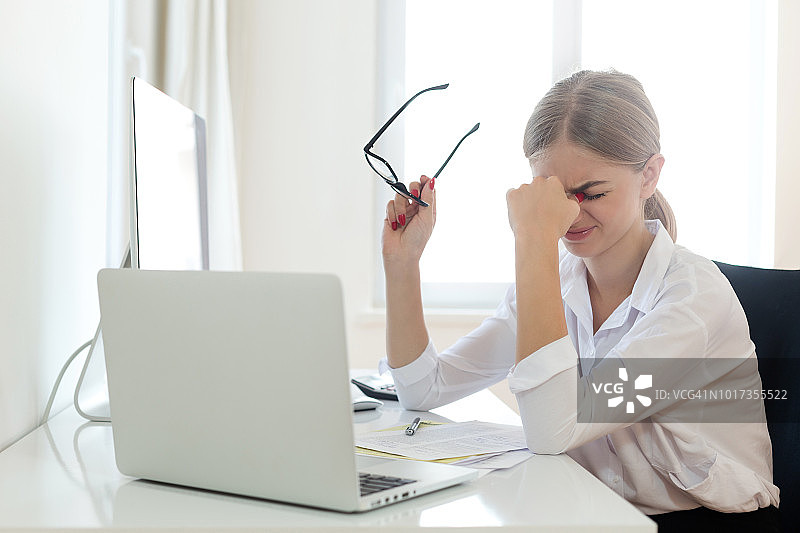 在办公室揉眼睛的女商人图片素材