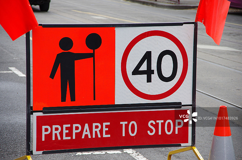 标志警告司机准备停车，保持在40公里每小时的速度限制，并注意工人与一个停止标志图片素材