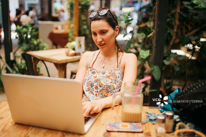 年轻自由职业女性在泰国咖啡馆完成工作图片素材
