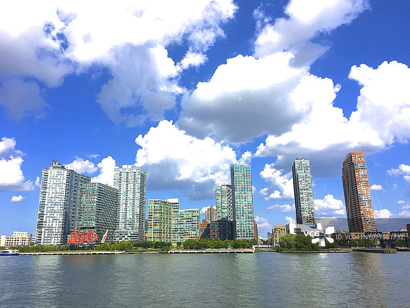 东河，蓬松云朵下的公寓大楼，长岛市图片素材