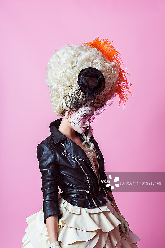 戴巴洛克假发和皮夹克的现代女性肖像，粉色背景图片素材