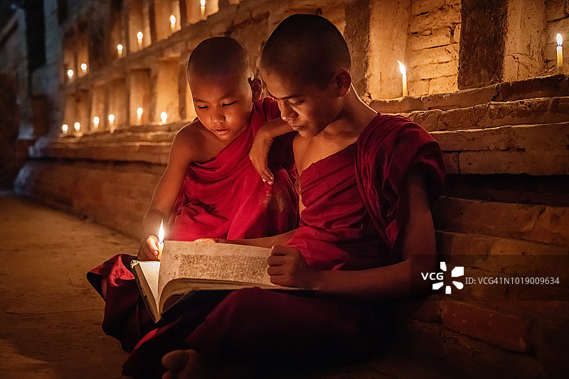 缅甸烛光寺庙里一起读书的小沙弥图片素材