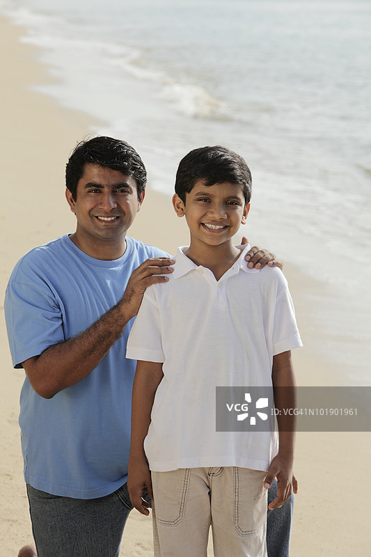 父亲微笑着握住儿子的肩膀图片素材